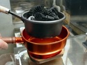 火熾し器の中の炭を移動する